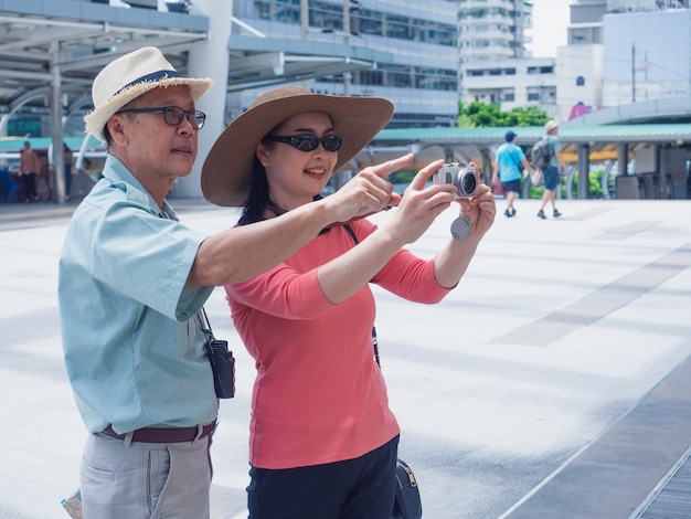 写真 高齢者のカップル旅行都市、高齢者の男性と女性は都市のカメラで何かを撮る