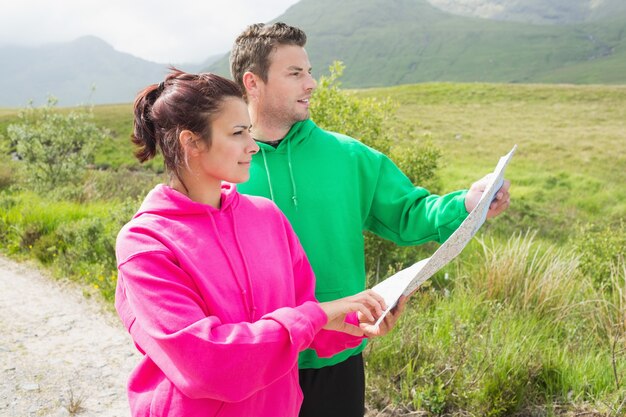 Couples holding a map and looking ahead