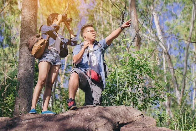 couples with Binoculars over the cliff Looking for something in the forest