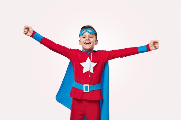 Courageous superhero kid smiling happily at camera