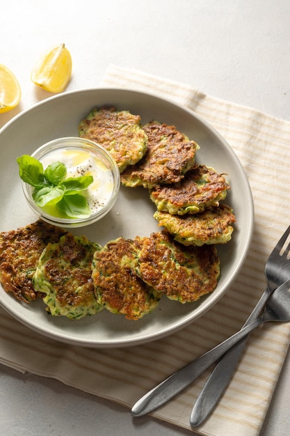 Courgette beignets of vegetarische courgette pannenkoeken geserveerd met yoghurtsaus bovenaanzicht