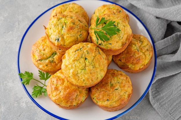 Courgette muffins met kaas knoflook en kruiden op een grijze betonnen achtergrond Vegetarische schotel