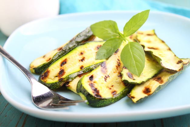 Courgette op een blauwe plaat met basilicum, selectieve nadruk wordt geroosterd die.