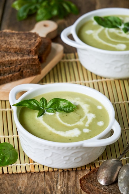 Courgette roomsoep met basilicum in witte kommen