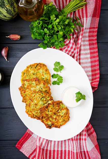 Courgettepannekoeken met peterselie op een houten lijst.