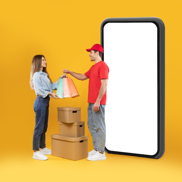 Courier Delivering Order To Female Standing Near Smartphone In Studio