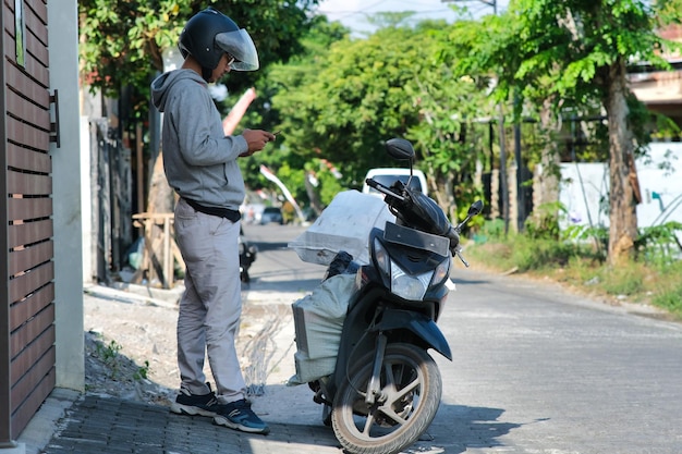 Photo courier delivering packages using motorbike in yogyakarta indonesia 25 july 2023