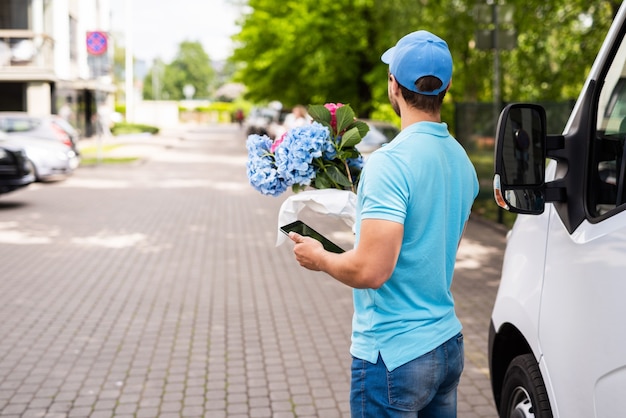 Courier during flowers delivery is waiting for a client