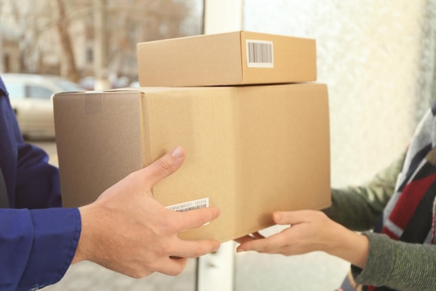 Courier giving parcels to customer closeup