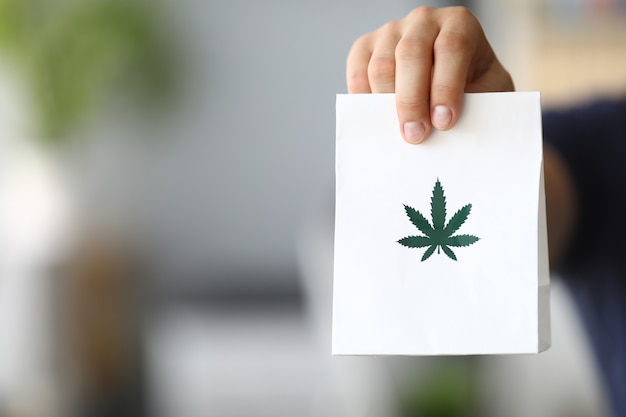 Courier hand passing package with marijuana