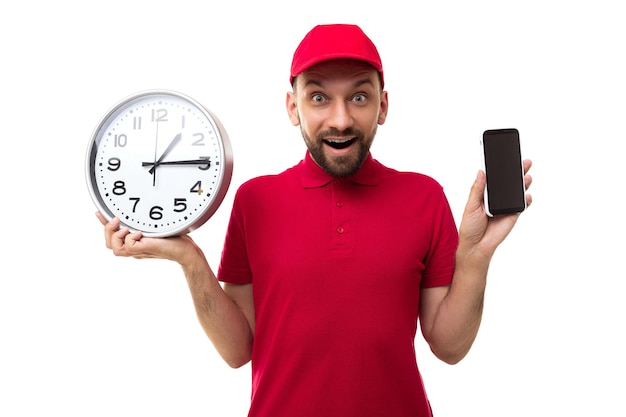 Courier holds a huge watch in his hands and demonstrates the screen of a smartphone in a red uniform