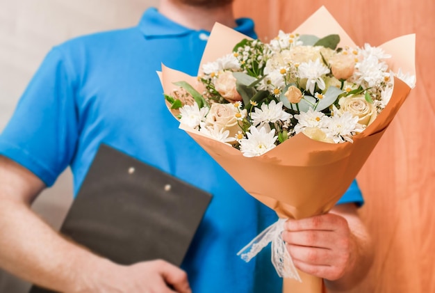 Courier holds out a bouquet of flowers home delivery of flowers