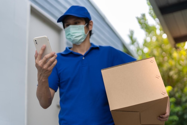 The courier holds the parcel and sees the recipient's address via a smartphone delivery man