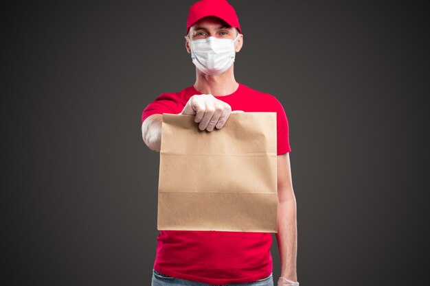 Courier in protective mask delivering order to client