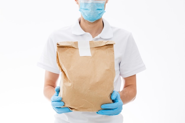 보호 마스크와 의료용 장갑을 낀 택배는 테이크아웃 음식을 배달합니다. 검역, 질병 발생, 코로나바이러스 코비드-19 전염병 상황에서 배달 서비스.
