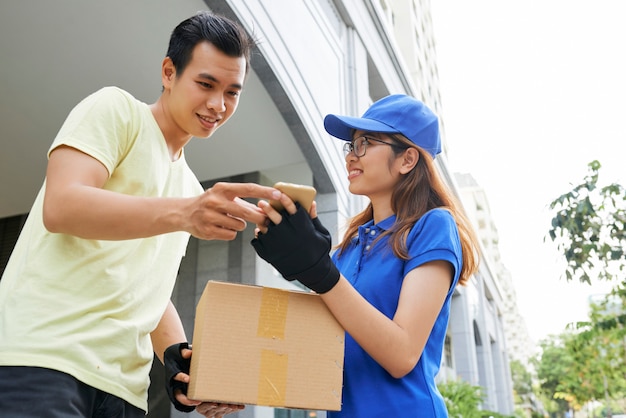 Courier showing smartphone to client