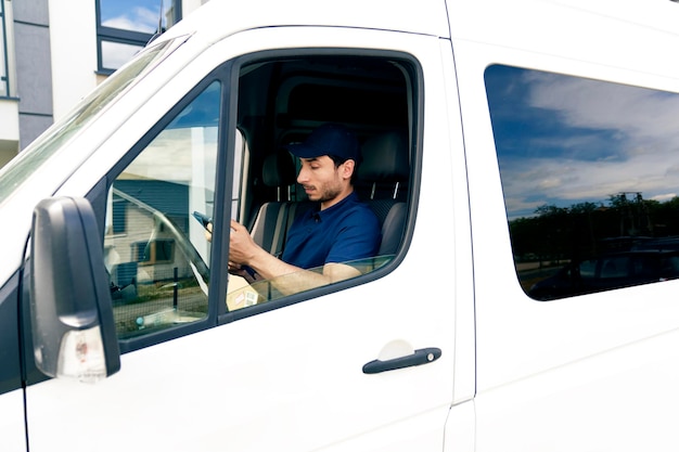 Courier using digital tablet while sitting in car