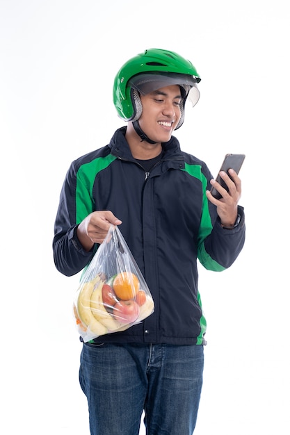 Courier wearing helmet and jacket uniform holding food isolated