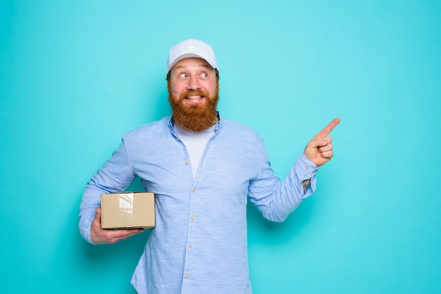 Courier with carton box in hand is surprised and indicates something