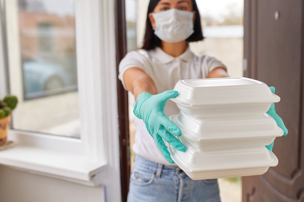 Courier woman hold go box food, delivery service, Takeaway restaurants food delivery to home door, Stay at home safe lives from coronavirus COVID-19 outbreak, Delivery service under quarantine.