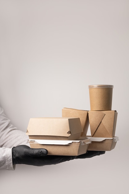 Couriers hand in a glove holds a delivery box