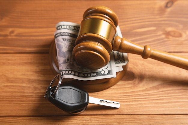 Court gavel with money and car keys on the table