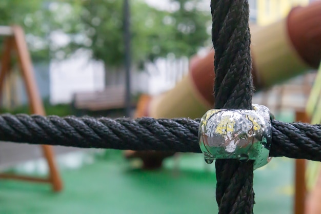 A courtyard of high-rise buildings with a modern and large playground made of wood and plastic on a rainy summer day without people. Empty outdoor playground. A place for children's games and sports.