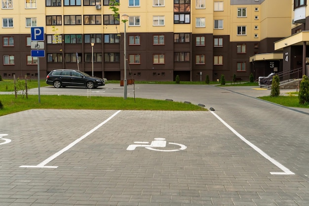 Photo the courtyard of a large multistorey residential complex in the summer with parking spaces for cars parking spaces for drivers with disabilities