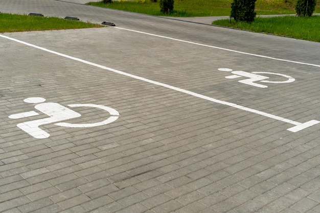 The courtyard of a large multistorey residential complex in the\
summer with parking spaces for cars parking spaces for drivers with\
disabilities