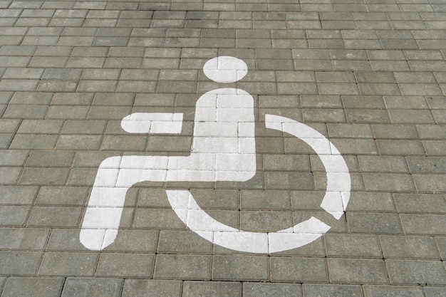 The courtyard of a large multistorey residential complex in the\
summer with parking spaces for cars parking spaces for drivers with\
disabilities