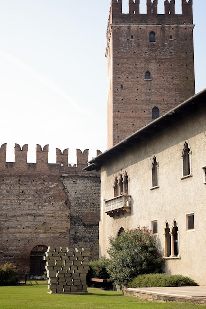 The courtyard of a medieval fortress in Italy with a tower balcony and loopholes