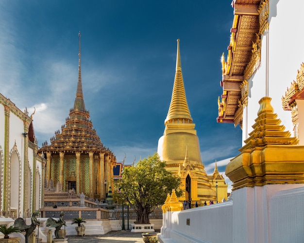 Courtyard of ornate Buddhist temples with golden and colorful decorative details Bangkok Thailand