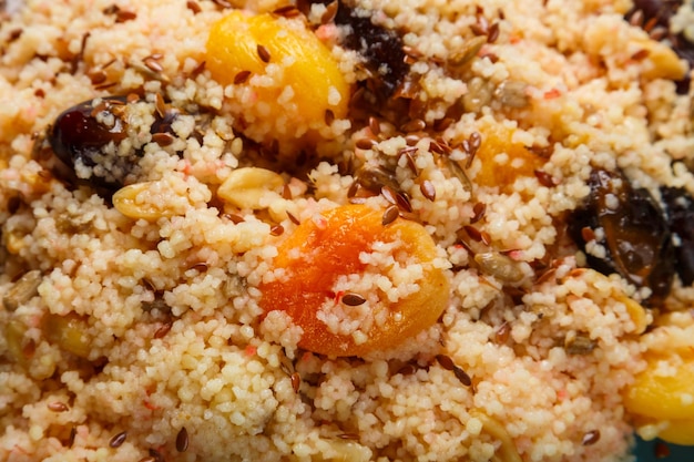 Cous cous with dried fruits saffron and nuts depraved closeup