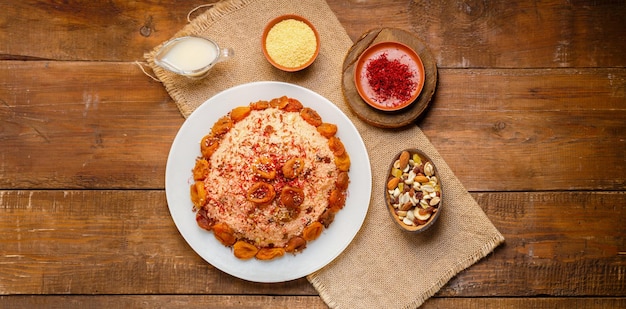 Couscous on almond milk with dried fruits and nuts on a table on a napkin next to milk and saffron