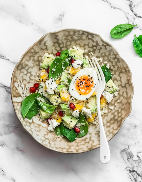 Couscous avocado spinach mango feta salad and boiled egg delicious healthy breakfast snack on a light background top view