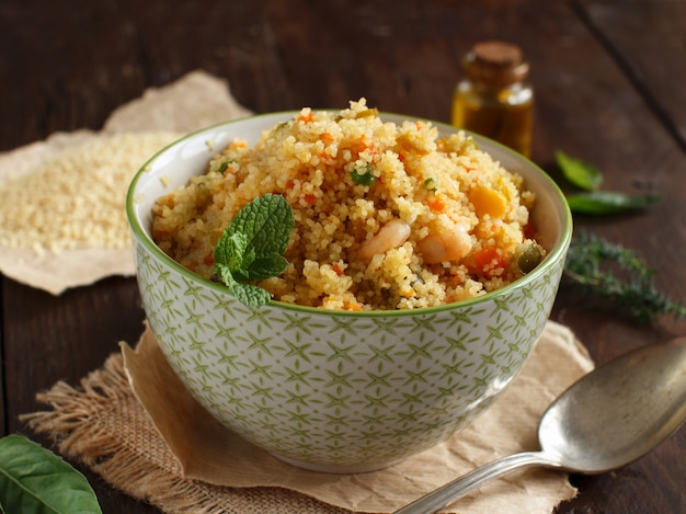 Couscous met garnalen en groenten in een kom van dichtbij