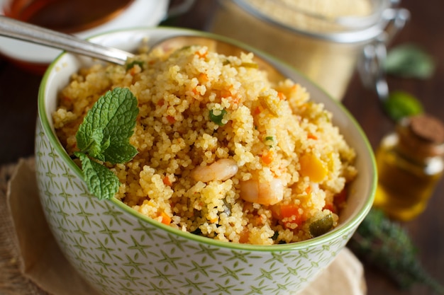 Couscous met garnalen en groenten in een kom van dichtbij