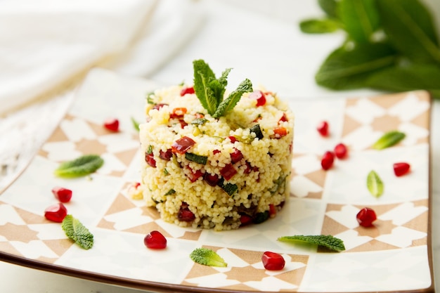 Couscous salad with pomegranate and mint leaves