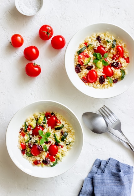 Couscous salad with tomatoes, peppers, courgettes and cranberries. Vegetarian food. Diet. Healthy eating.