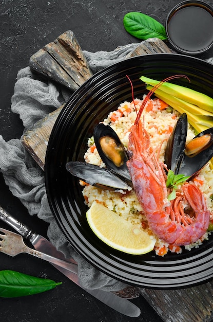 Couscous with avocados and seafood Shrimp and mussels On the old background Top view Free space for your text