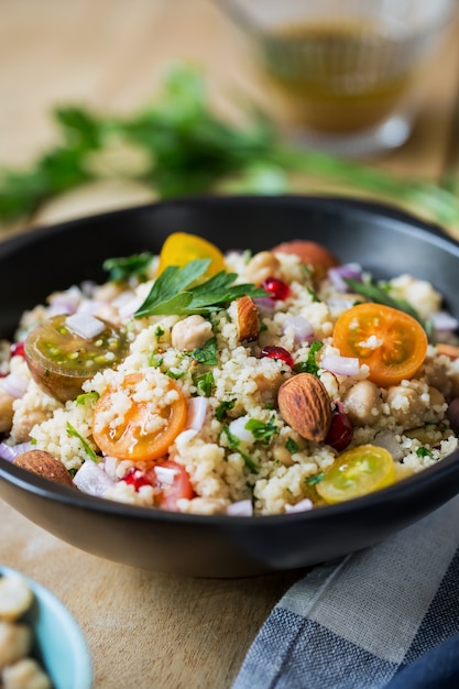 Cous cous con insalata di melograno e mandorle con condimento per insalata