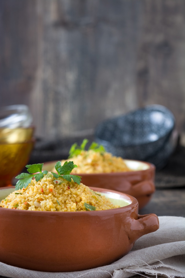 Photo couscous with vegetables in bowl on wood table