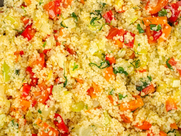 Couscous with vegetables in frying pan. Moroccan cuisine dish. 