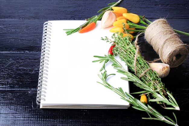Cover kookboek notebook op een zwarte houten tafel kruiden recept voor knoflook tijm peper