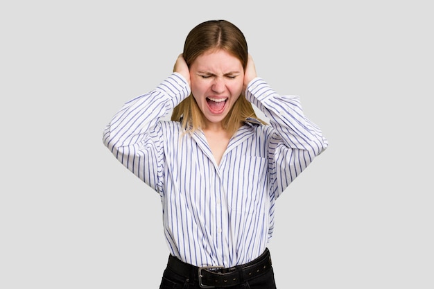 Covering ears with hands trying not to hear too loud sound