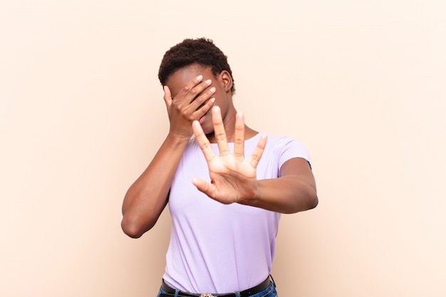 covering face with hand and putting other hand up front to stop camera, refusing photos or pictures