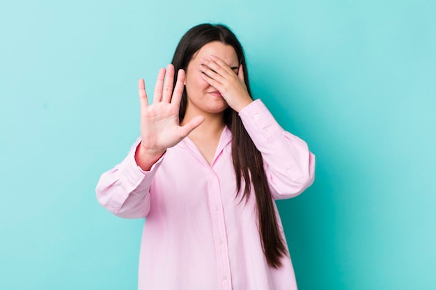 Covering face with hand and putting other hand up front to stop camera refusing photos or pictures