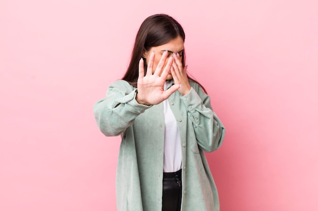 Covering face with hand and putting other hand up front to stop camera refusing photos or pictures