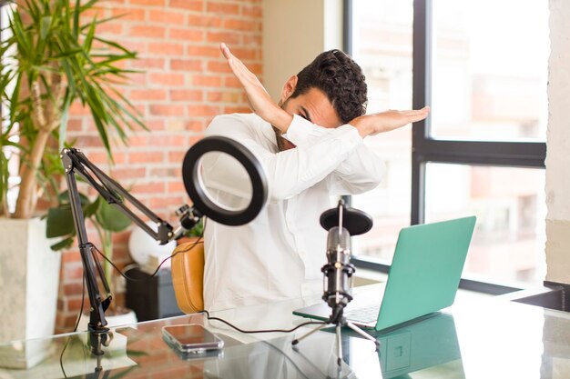 Covering face with hand and putting other hand up front to stop camera refusing photos or pictures