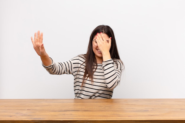 covering face with hand and putting other hand up front to stop camera, refusing photos or pictures